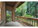 Covered porch featuring a wooden railing overlooking lush green trees and vegetation at 4511 Crab Creek Dr # 101, Raleigh, NC 27612