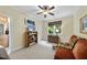 Comfortable bedroom with a cozy sofa, built-in shelving, and a window with wooded views at 517 Belmont Cir, Wake Forest, NC 27587