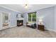 Bonus room featuring a fireplace, large window with wooded views, and neutral carpet at 517 Belmont Cir, Wake Forest, NC 27587