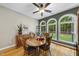 Bright dining room with hardwood floors, round wood table, and large windows with wooded views at 517 Belmont Cir, Wake Forest, NC 27587
