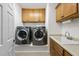Neat laundry room featuring stainless steel washer and dryer and adjacent sink at 517 Belmont Cir, Wake Forest, NC 27587
