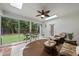 Bright sunroom featuring a leafy ceiling fan, skylights, and views of the backyard at 517 Belmont Cir, Wake Forest, NC 27587