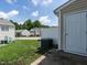 Backyard area with grass, an A/C unit, and a white privacy fence at 5225 Big Bass Dr, Raleigh, NC 27610