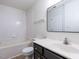 Well-lit bathroom features a tub, toilet, dark vanity, and a large mirror at 5225 Big Bass Dr, Raleigh, NC 27610