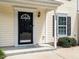 Close-up of front door with a black frame, a side window, and clean landscaping at 5225 Big Bass Dr, Raleigh, NC 27610