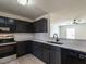 Open kitchen featuring black cabinets and stainless appliances with hardwood floors at 5225 Big Bass Dr, Raleigh, NC 27610