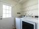 Bright laundry room with white front load machines and door to exterior at 5225 Big Bass Dr, Raleigh, NC 27610