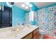 Full bathroom featuring a double vanity, colorful shower curtain, and blue walls at 534 Siltstone Pl, Cary, NC 27519