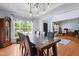 Open-concept dining room with wood floors, stylish lighting, and multiple windows at 534 Siltstone Pl, Cary, NC 27519