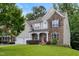 Beautifully landscaped home with stone and siding, featuring a covered porch and mature trees at 534 Siltstone Pl, Cary, NC 27519