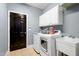 Well-organized laundry room with sink, washer, dryer and cabinets at 534 Siltstone Pl, Cary, NC 27519