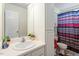 Clean bathroom features white vanity with a large mirror, and a shower with a colorful curtain at 6001 Winged Willet Ct, Wendell, NC 27591
