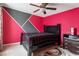 Stylish bedroom with bold pink accent walls, black furniture, and modern ceiling fan at 6001 Winged Willet Ct, Wendell, NC 27591