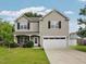 Charming two-story home featuring a well-maintained lawn and a two-car garage with ample parking space at 6001 Winged Willet Ct, Wendell, NC 27591