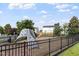 Community playground offers a secure fenced area with a climbing wall, slide, and swing set for enjoyment at 6001 Winged Willet Ct, Wendell, NC 27591