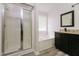 Bright bathroom showcasing a glass-enclosed shower and a soaking tub by a window at 616 Cheselden Dr, Durham, NC 27713