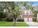 Charming two-story brick home features a well-manicured lawn, mature trees, and a two-car garage at 616 Cheselden Dr, Durham, NC 27713