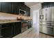Close-up of kitchen features stainless steel appliances, black cabinetry, and granite countertops at 616 Cheselden Dr, Durham, NC 27713