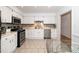 Bright kitchen with white cabinetry, stainless steel appliances, tile backsplash, and adjacent dining area at 6213 Fountainhead Dr, Raleigh, NC 27609