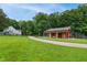 Barn and house on expansive green property, complete with a winding gravel driveway at 633 Fleming Rd, Youngsville, NC 27596
