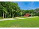 Picturesque red barn with lush green surroundings under a bright blue sky at 633 Fleming Rd, Youngsville, NC 27596