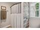 Bathroom with wood accent wall, shower with curtain, and neutral-colored towel at 633 Fleming Rd, Youngsville, NC 27596