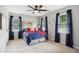 Bright bedroom with a ceiling fan, three windows, and carpet flooring at 633 Fleming Rd, Youngsville, NC 27596