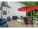 Cozy deck featuring a red umbrella, outdoor seating, and a grill, ideal for outdoor dining and gatherings at 633 Fleming Rd, Youngsville, NC 27596