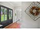Elegant entryway with black double doors, colorful rug, and decorative wreath creating a warm welcome at 633 Fleming Rd, Youngsville, NC 27596
