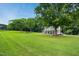 Spacious lawn leading up to a beautiful home with a covered porch and a lush tree canopy at 633 Fleming Rd, Youngsville, NC 27596