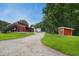 Scenic view of a two-story barn with black stairs, gravel driveway, and surrounding lush greenery at 633 Fleming Rd, Youngsville, NC 27596