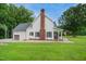 Side exterior of a home with a brick chimney, black shutters, and well-maintained lawn at 633 Fleming Rd, Youngsville, NC 27596
