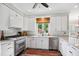 Updated kitchen has white cabinets, stainless appliances, and a colorful rug at 633 Fleming Rd, Youngsville, NC 27596