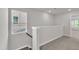 Bright hallway features a window with blinds and neutral carpet leading to other rooms in the home at 6549 Tremolo Trl, Raleigh, NC 27616