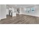 Bright living area with hardwood floors, and access to the staircase and stainless steel appliances at 6549 Tremolo Trl, Raleigh, NC 27616