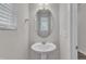 Stylish powder room with a pedestal sink, oval mirror, and modern fixtures at 6549 Tremolo Trl, Raleigh, NC 27616