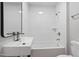 This bathroom features white tiling, sleek fixtures, and a tub with shower at 658 Love Grove Church Rd, Sanford, NC 27332