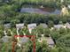 Aerial view of neighborhood near Veterans Park, featuring a serene lake with recreational dock at 709 Skymont Dr, Holly Springs, NC 27540