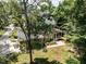 Aerial view of the house featuring mature trees, a back porch and a three car garage at 709 Skymont Dr, Holly Springs, NC 27540