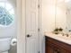 Bathroom featuring a vanity with marble countertop, toilet, and decorative oval window at 709 Skymont Dr, Holly Springs, NC 27540