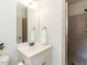 Bright bathroom featuring a white vanity with a large mirror and a walk-in shower with tile surround at 709 Skymont Dr, Holly Springs, NC 27540