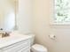 Half bath featuring a white vanity with brushed nickel finishes and a comfort height toilet at 709 Skymont Dr, Holly Springs, NC 27540