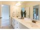 Bathroom with dual sinks, a large mirror, white cabinetry and a view of the walk-in shower at 709 Skymont Dr, Holly Springs, NC 27540