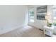 Bright, carpeted bedroom with neutral paint, double windows, and modern side table at 709 Skymont Dr, Holly Springs, NC 27540
