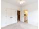Carpeted bedroom with a ceiling fan, closet, and open doorway leading to an en-suite bathroom at 709 Skymont Dr, Holly Springs, NC 27540