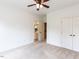 Carpeted bedroom with a ceiling fan, closet, and open doorway leading to an en-suite bathroom at 709 Skymont Dr, Holly Springs, NC 27540