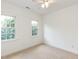 Bright bedroom featuring plush carpeting, two windows that let in natural light, and a ceiling fan at 709 Skymont Dr, Holly Springs, NC 27540