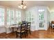 Bright dining area featuring hardwood floors, large windows with shutters, and elegant chandelier lighting at 709 Skymont Dr, Holly Springs, NC 27540