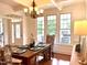 Elegant dining room with a chandelier, table setting, and large windows at 709 Skymont Dr, Holly Springs, NC 27540