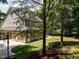 Charming home featuring an attached garage, lush green lawn and mature trees surrounding the property at 709 Skymont Dr, Holly Springs, NC 27540